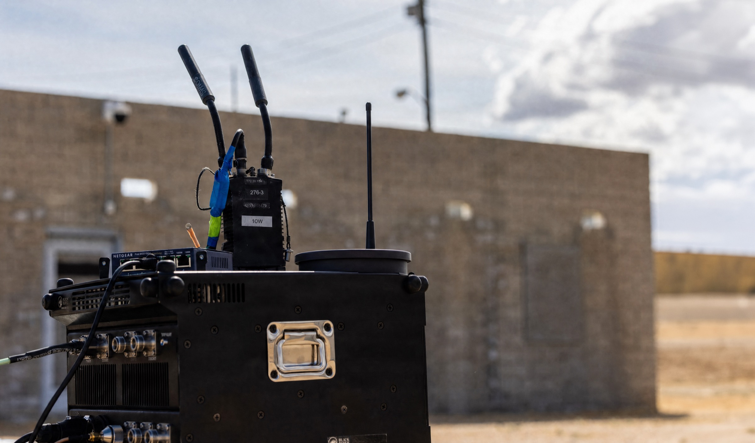 A ground vehicle fitted with Raven Net mesh antennas at a desert test site
